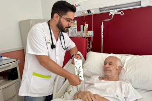 Un professional donant un díptic a un pacient hospitalitzat